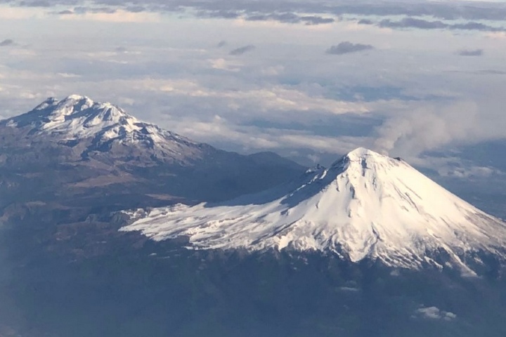 Vista aérea del Iztaccíhuatl y el Popocatépetl llenos de nieve. Foto: @webcamsdemexico | Twitter