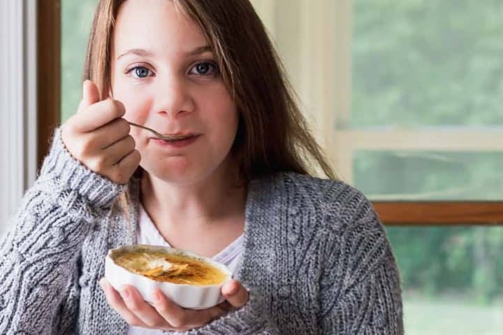 Chica comiendo Crème Brûlée. Foto: WildThistle Kitchen