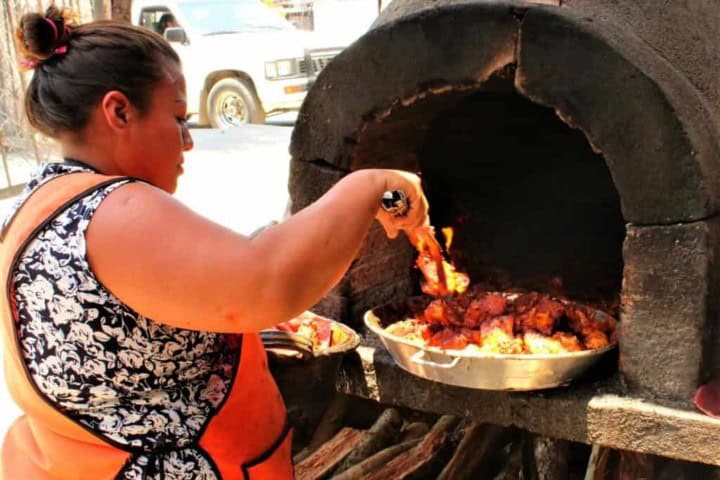 12. Mujer cocinando cochito al horno. Foto - México en mi Cocina