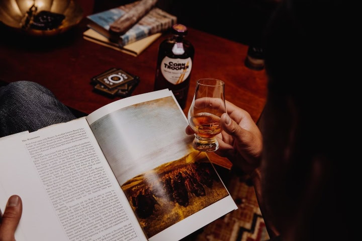 4. Mujer tomando whisky mientras lee. Foto - Taylor Brandon (Unsplash)