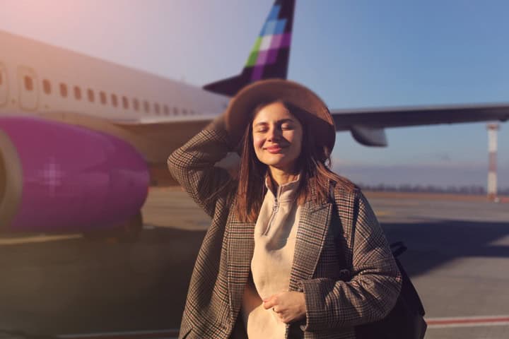 1. Viajera frente a avión de Volaris. Foto - Volaris (Facebook)