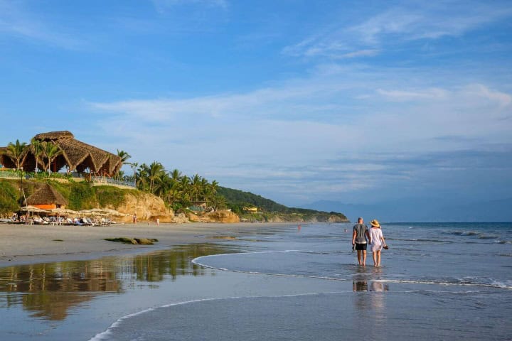 1. Pareja caminando por la Playa Destiladera, en la Riviera Nayarit. Foto - Alamy