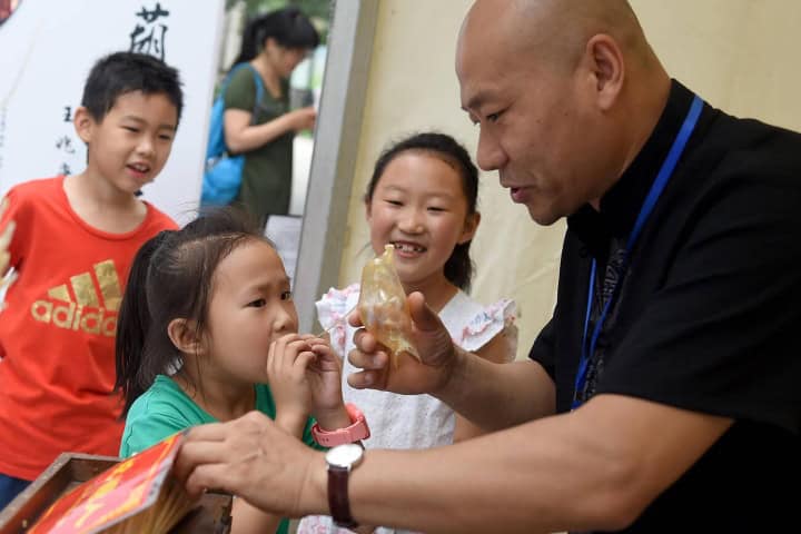 10. Hombre dejando que niña infle su dulce. Foto - Alamy