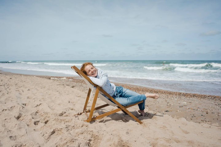 2. Mujer feliz en la playa. Foto - Alamy