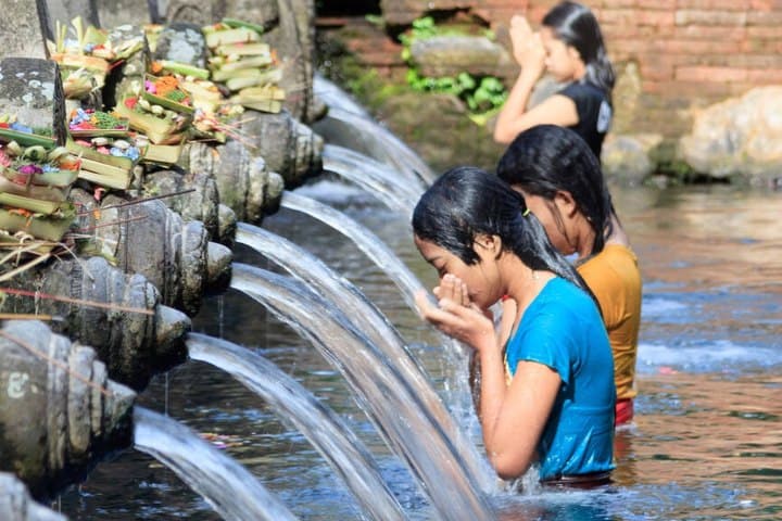 5. Mujer bebiendo agua del Templo Tirta Empul en Bali, Indonesia. Foto - Alamy