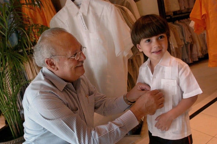1. Hombre colocando guayabera a niño. Foto - Getty Images