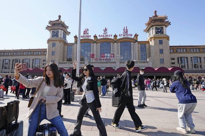 7. Personas frente a la estación de Pekín, en China. Foto - Alamy