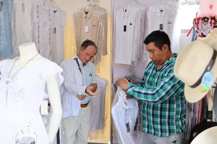 8. Hombres probandose guayaberas. Foto - Tekit Capital de la Guayabera (Facebook)