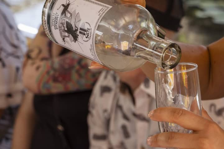 1. Mano sirviendo mezcal. Foto - Adelitas Empresarias (Facebook)