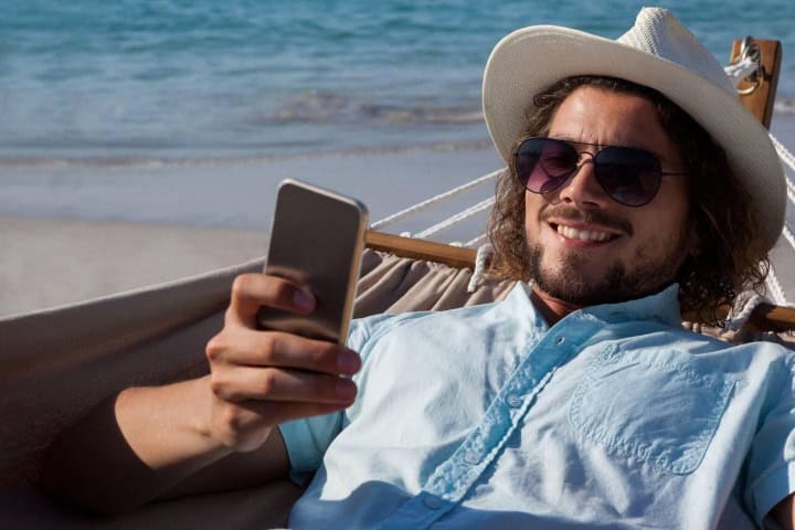 11. Viajero en la playa con celular. Foto - Alamy (Fin de semana completo en Veracruz)
