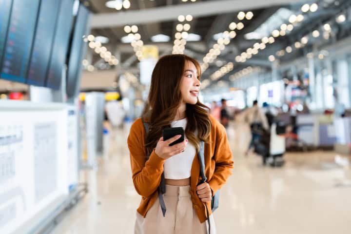 5. Mujer en aeropuerto con celular. Foto - RedPocket