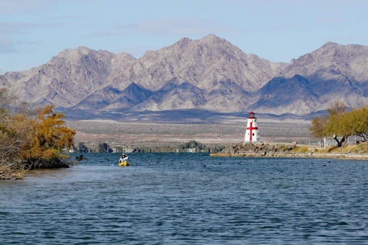 7. Persona haciendo kayak en el Lago Havasu con una replica de faro de fondo. Foto - Alamy
