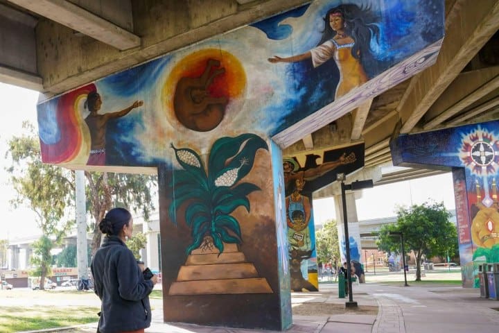12. Visitante mirando los murales del Parque Chicano. Foto - Alamy