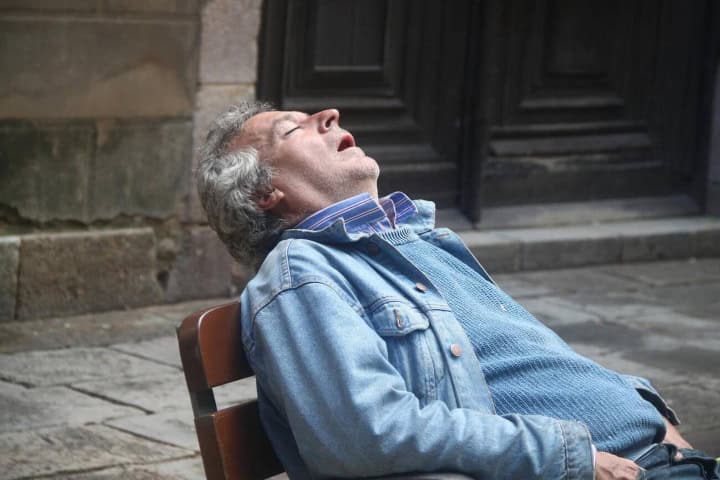 2. Persona dormida en banca. Foto - Alamy