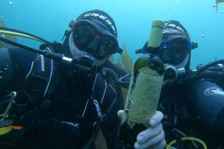 3. Buzos con botella de vino. Foto - Ven a Galicia