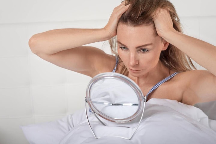 5. Mujer mirando su piel. Foto - Alamy (Cuidado de sol)