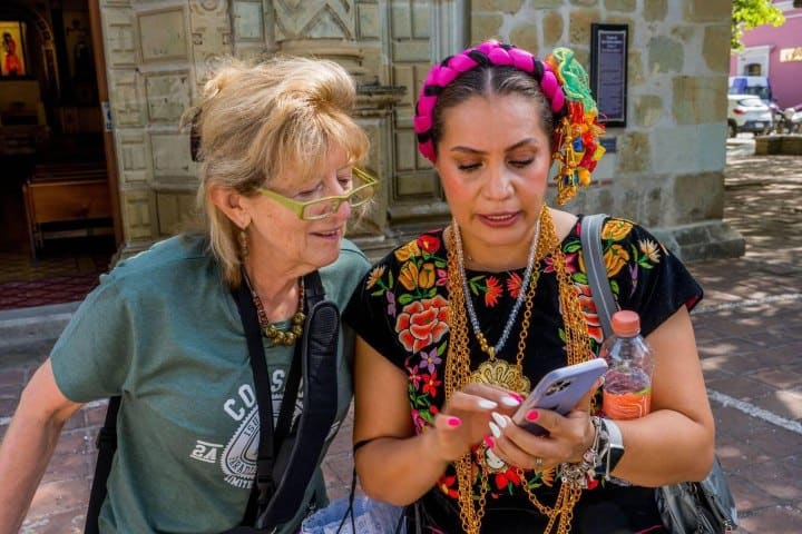 7. Viajera siendo ayudada por mexicana en el Barrio de Jalatlaco, Oaxaca. Foto - Alamy