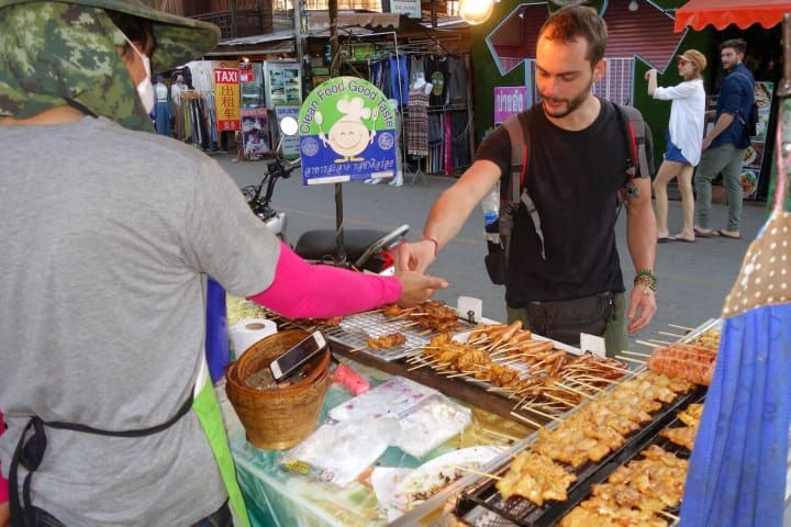 8. Viajero comprando comida callejera en Tailandia. Foto - Alamy