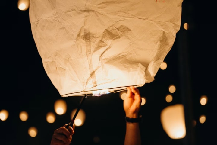 EXTRA. Mano encendiendo un globo de cantoya. Foto - Leon Contreras (Unsplash)