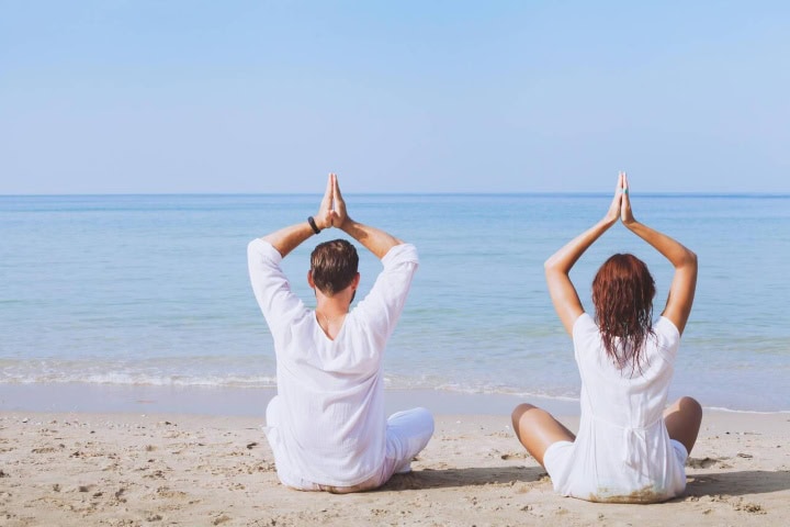 1. Personas haciendo yoga frente al mar. Foto - Alamy