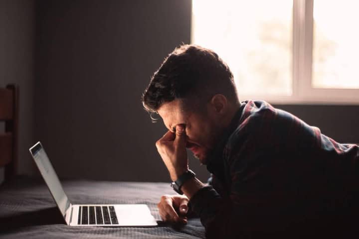 4. Hombre triste en computadora. Foto - Alamy