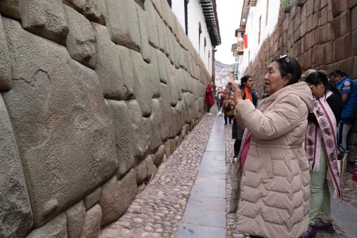 6. Mujer fotografiando la piedra de los 12 ángulos. Foto - EFE