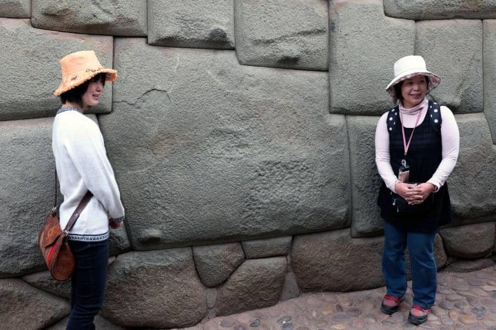 8. Viajeras frente a la piedra de los 12 ángulos. Foto - Alamy