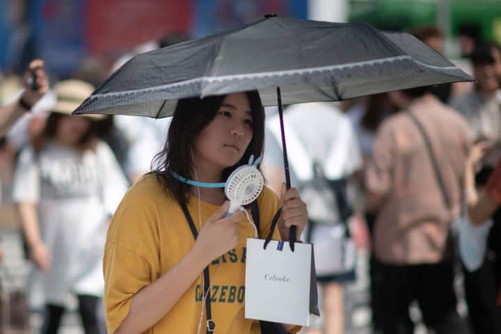 3. Japonesa con sombrilla y ventilador portátil. Foto - WUNC