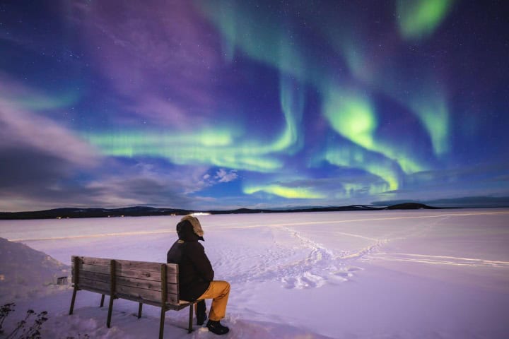 5. Viajero mirando auroras boreales en la Laponia Finlandesa. Foto - Getty Images