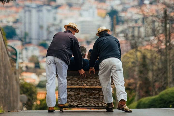 8. Carreiros do Monte empujando un carro de cesto. Foto - Visit Madeira