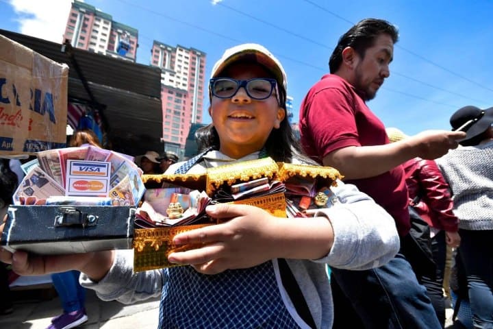5. Niña con alasitas de billetes. Foto - Alamy