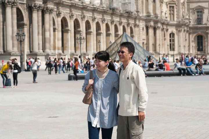 5. Pareja japonesa frente al museo Louvre. Foto - Alamy