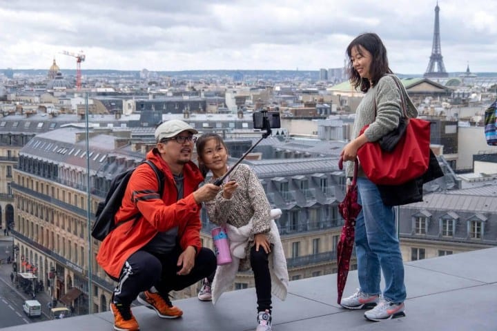 6. Familia asiática tomándose una foto en París. Foto - Alamy
