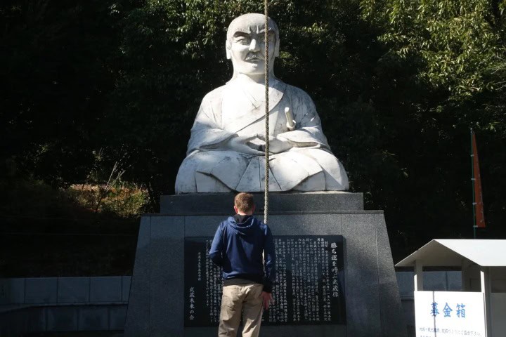 3. Viajero mirando escultura de Miyamoto Musashi. Foto - u/ArtNo636 (Reddit)