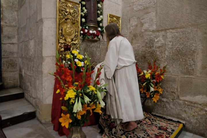 4. Persona vestida de blanco rezando en el la Columna de la Flagelación de Jesús. Foto - Alamy
