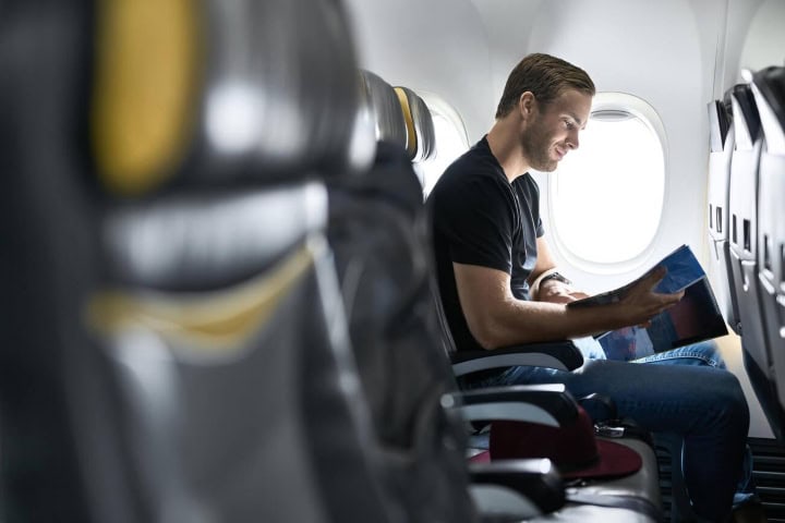 7. Hombre feliz en avión. Foto - Alamy