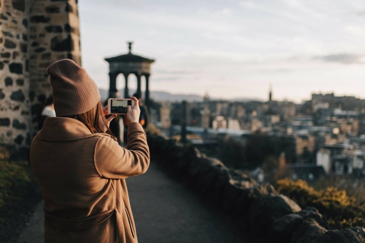 1. Mujer tomando foto desde la colina Calton Hill. Foto - Westend61