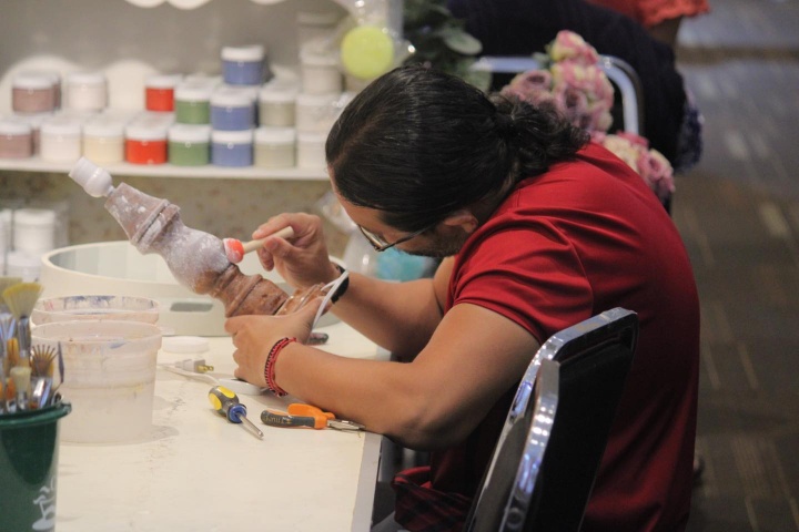 1. Asistente pintando pieza durante la Expo Manualidades e Ideas Creativas. Foto - @wtcveracruz (Instagram)