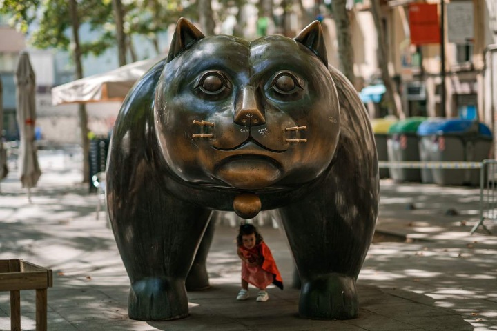 7. Niña jugando bajo el Gato de Botero. Foto - Shutterstock