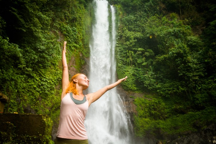 6. Mujer frente a cascada. Foto - Freepik