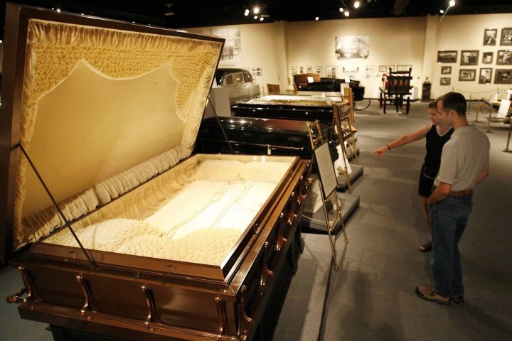 1. Visitantes mirando ataúd para 3 personas en el Museo Nacional de Historia Funeraria. Foto - Alamy
