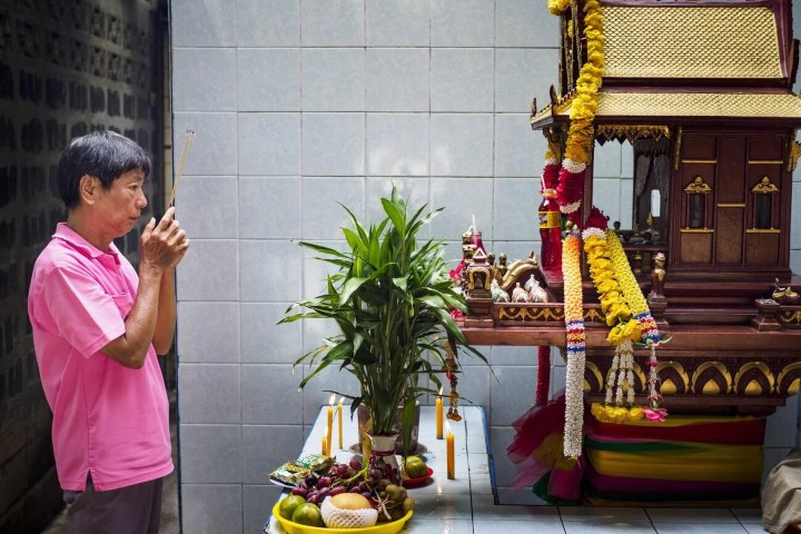 2. Hombre rezando frente a ofrenda durante el Festival de los Fantasmas Hambrientos. Foto - Alamy