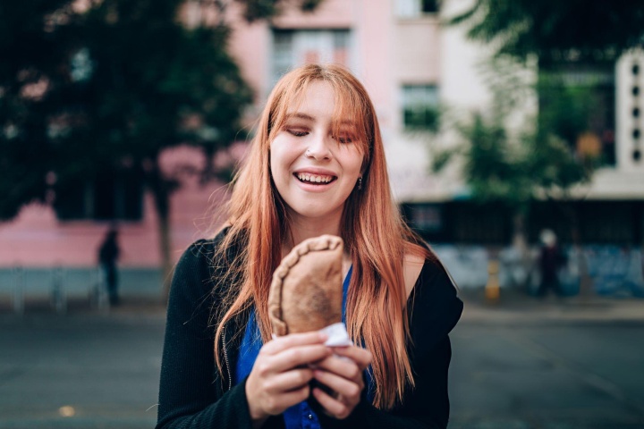 6. Mujer comiendo empanada. Foto - Getty Images (Día Mundial de la Empanada)