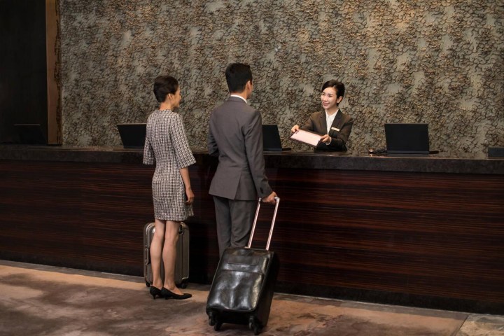 3. Huéspedes en lobby de hotel. Foto - Alamy