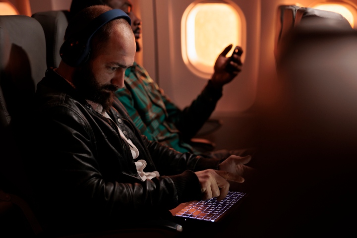 3. Pasajeros en avión utilizando dispositivos. Foto - DC Studio (Magnific)
