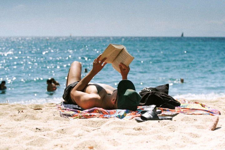 7. Hombre leyendo en la playa. Foto - Lawrence Krowdeed (Unsplash)
